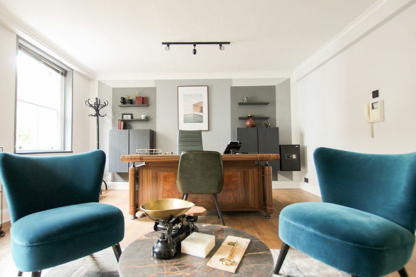 Executive desk with olive green chair and teal armchairs.